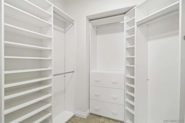 a view of walk in closet with empty racks