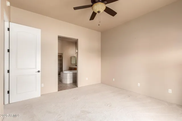 a view of empty room with wooden floor and ceiling fan
