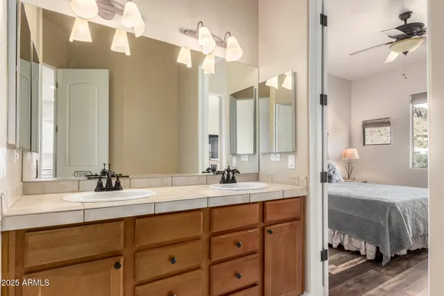 a bathroom with a double vanity sink a mirror and a bathtub