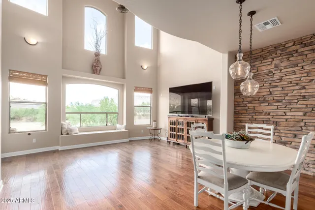 a dining room with furniture a chandelier and wooden floor