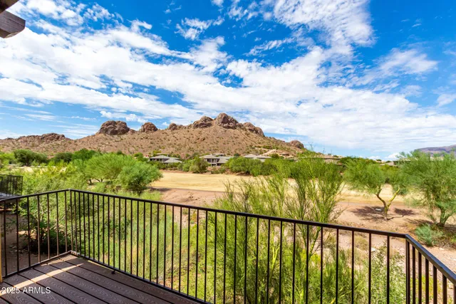 a view of a balcony with wooden floor & fence