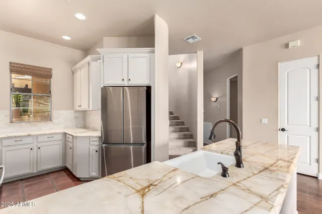 a kitchen with a sink stainless steel appliances and refrigerator