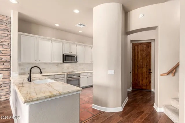 a kitchen with a sink a refrigerator and cabinets