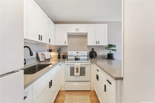 a white kitchen with a sink and cabinets
