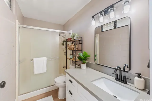 a bathroom with a granite countertop sink toilet and shower