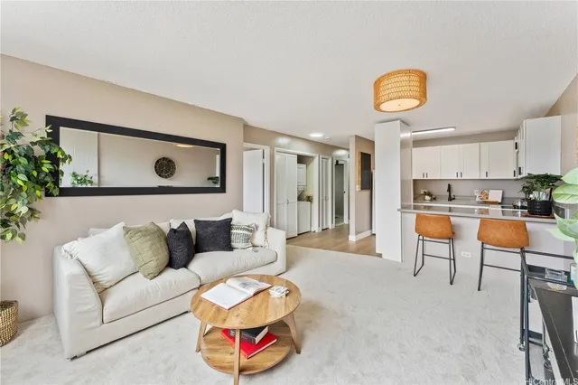 a living room with furniture and kitchen view