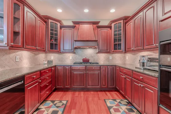 a kitchen with stainless steel appliances granite countertop wooden cabinets a sink and dishwasher