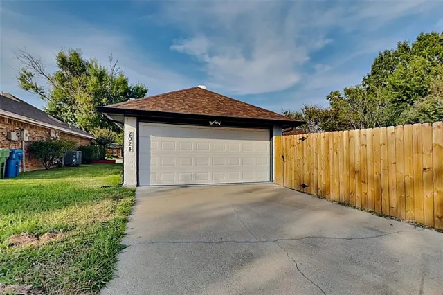 a front view of a house with a garden and trees