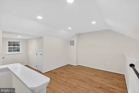 a view of a room with wooden floor and white walls