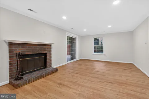 a view of empty room with wooden floor and fireplace