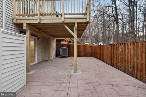 a view of backyard with barbeque grill and wooden fence