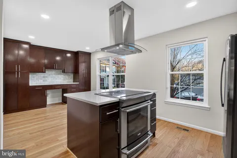 a kitchen with a stove and a wooden floor