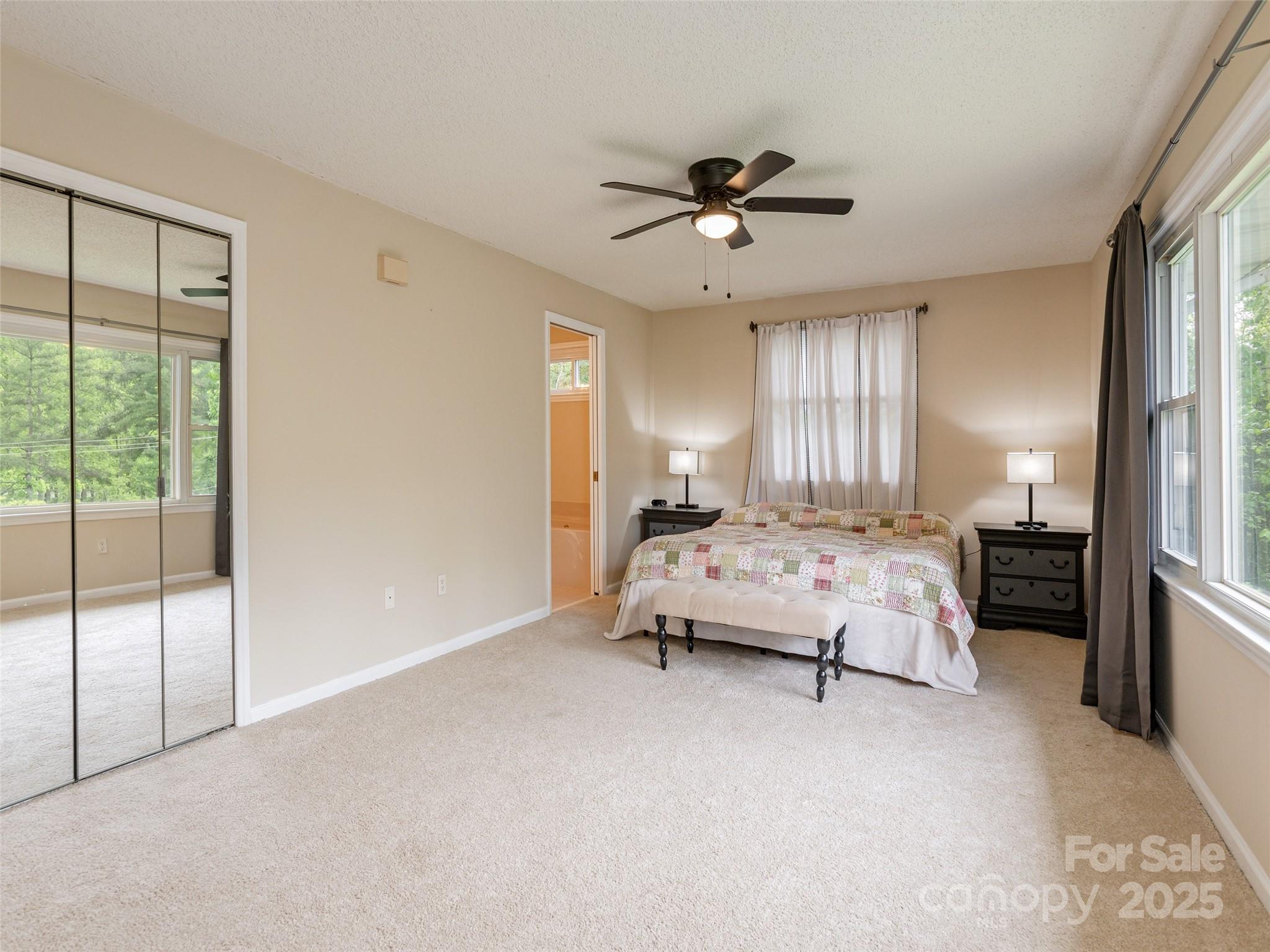 61 West Lake View Road Hendersonville, NC 28739 - Photo 18 of 37 a spacious bedroom with a bed and a chandelier