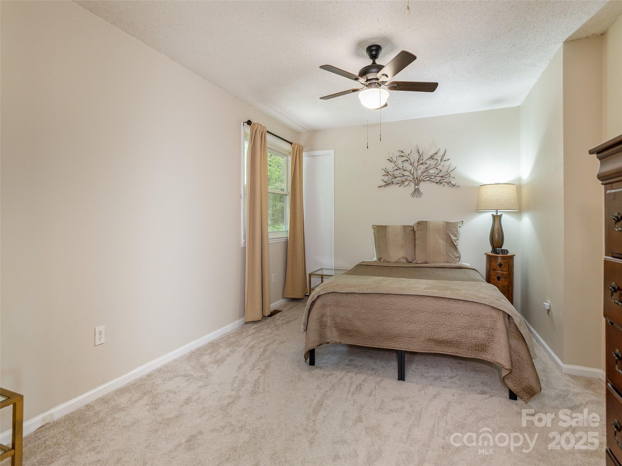 61 West Lake View Road Hendersonville, NC 28739 - Photo 23 of 37 a bedroom with a bed and a chandelier