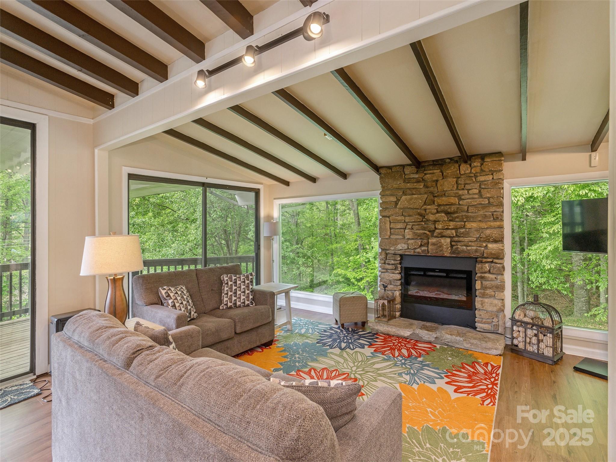 61 West Lake View Road Hendersonville, NC 28739 - Photo 5 of 37 a living room with furniture a fireplace and a floor to ceiling window