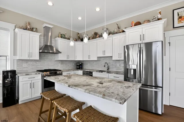 a kitchen with stainless steel appliances granite countertop a refrigerator stove microwave and sink