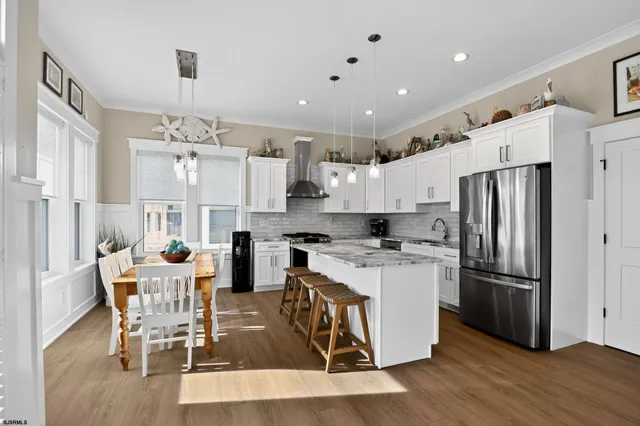a kitchen with stainless steel appliances kitchen island granite countertop a refrigerator and a stove top oven