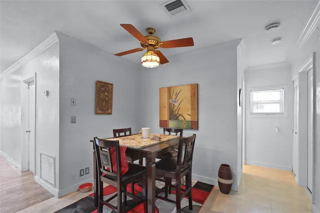 a view of a dining room with furniture and a chandelier fan