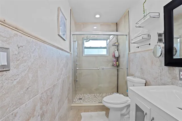 a bathroom with a granite countertop toilet a sink and a shower