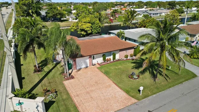 an aerial view of a house with outdoor space and trees all around