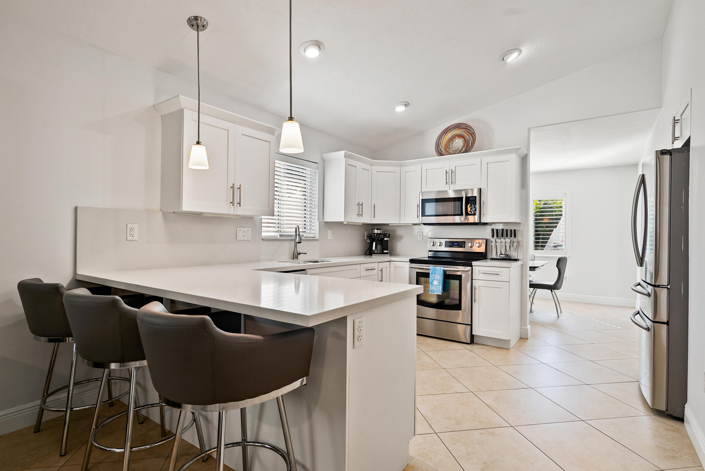 37 Bonefish Avenue Key Largo, FL 33037 - Photo 16 of 22 a kitchen with kitchen island granite countertop a sink a counter top space appliances and cabinets