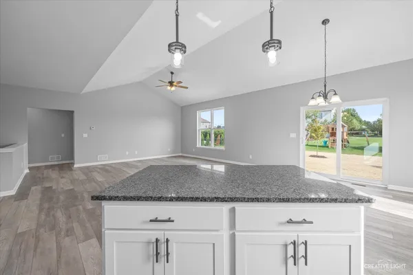 a kitchen that has a sink window and cabinets