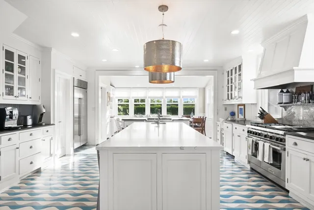 a kitchen with stainless steel appliances a stove a sink a oven a counter space and a window