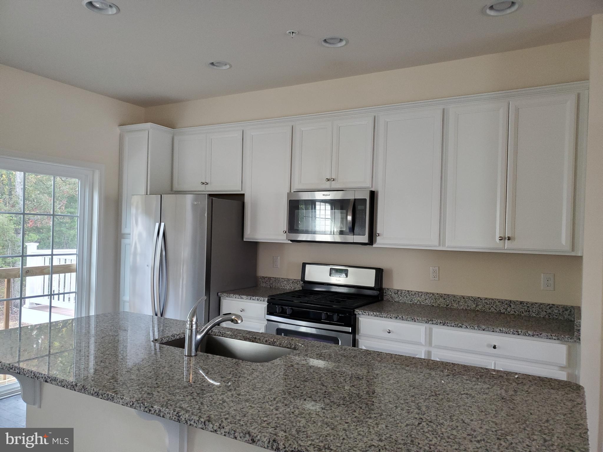 33 Iron Gate Road Sicklerville, NJ 08081 - Photo 3 of 16 a kitchen with stainless steel appliances granite countertop a refrigerator a stove a sink and white cabinets