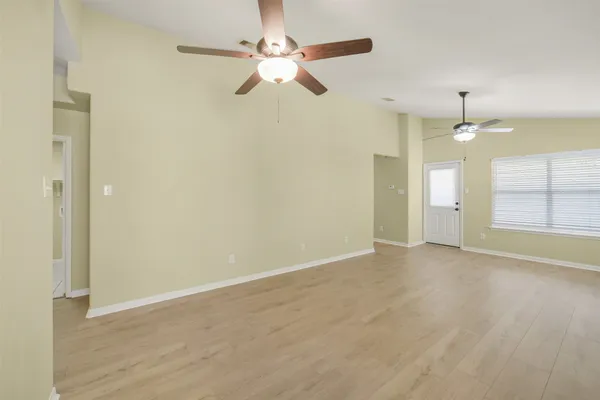 an empty room with fan and windows