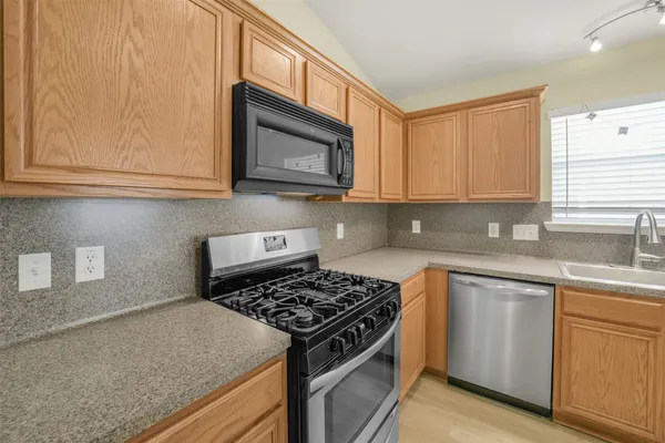 a kitchen with stainless steel appliances granite countertop a sink stove and microwave