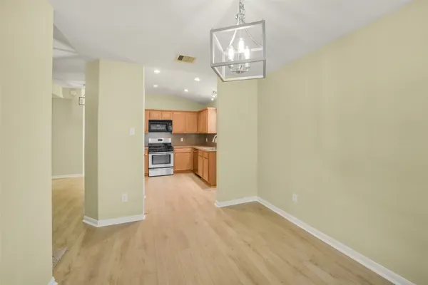 a view of a kitchen with wooden floor and stainless steel appliances