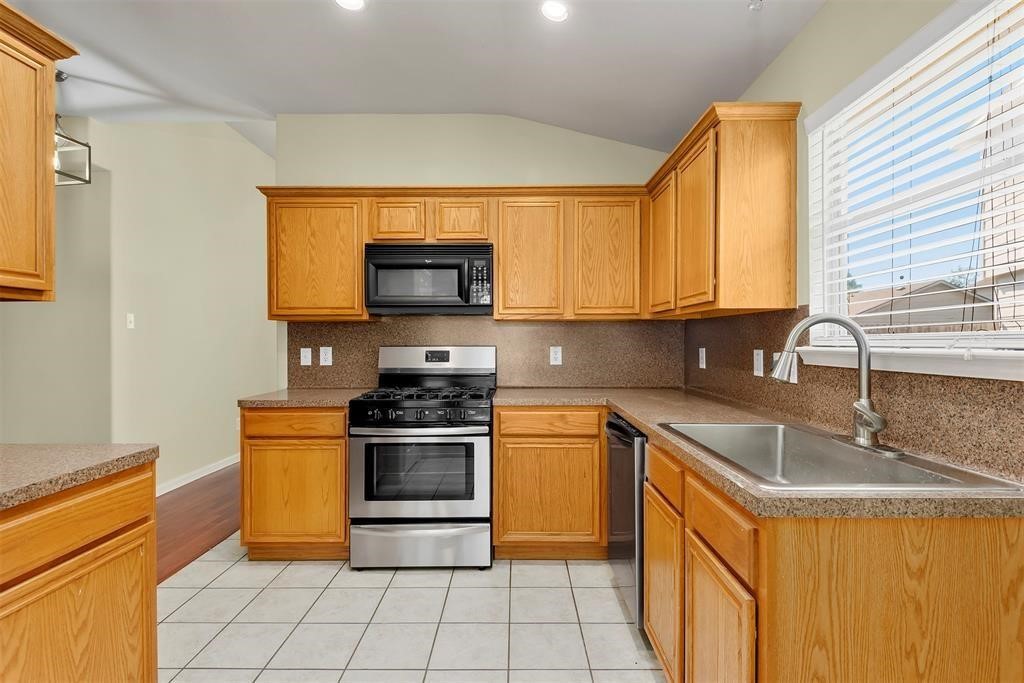 20231 Ribbonwood Point Court Tomball, TX 77375 - Photo 3 of 10 a kitchen with stainless steel appliances granite countertop a sink and a stove