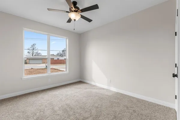a view of an empty room with a ceiling fan