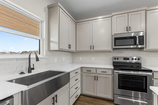 a kitchen with cabinets stainless steel appliances a sink and a microwave