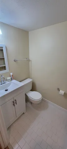 a bathroom with a granite countertop toilet and a sink