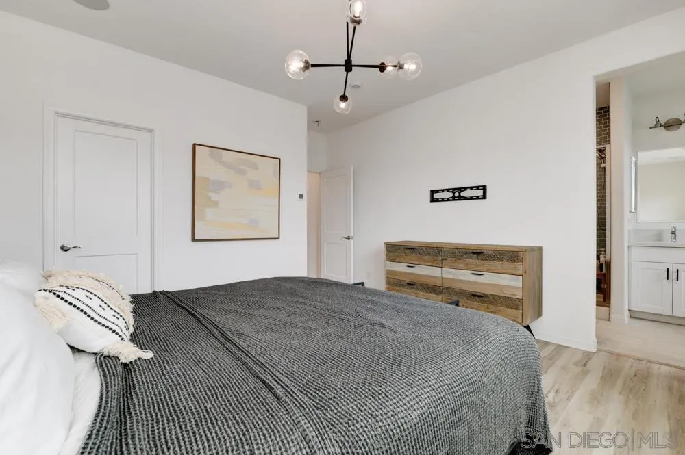 1643 Fig Tree Way Oceanside, CA 92056 - Photo 16 of 29 a bedroom with a bed and a chandelier
