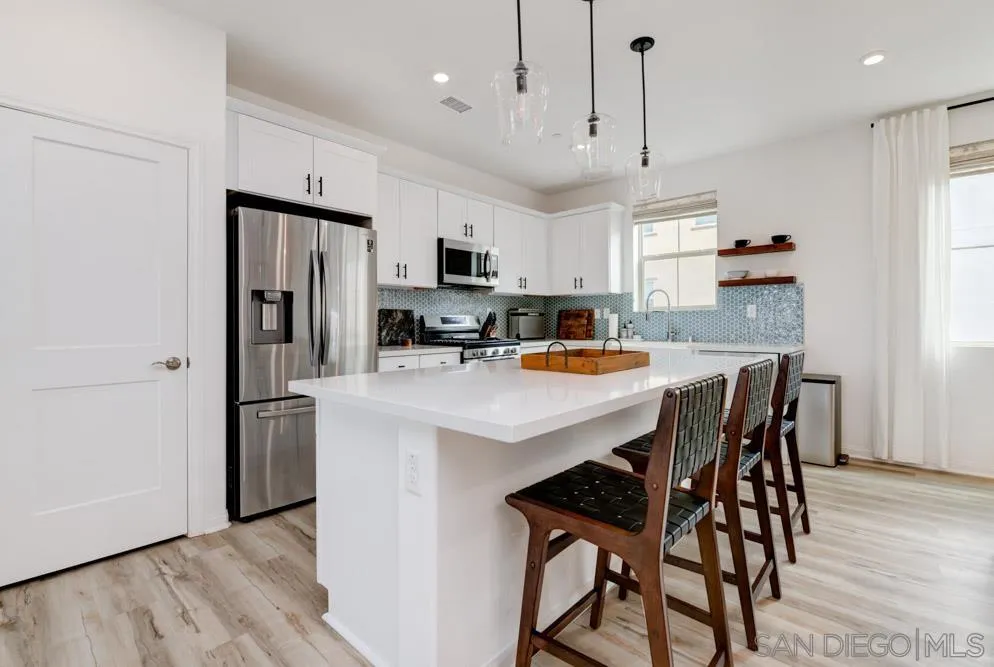 1643 Fig Tree Way Oceanside, CA 92056 - Photo 6 of 29 a kitchen with kitchen island a refrigerator a stove a microwave oven a sink dishwasher and a refrigerator with wooden floor