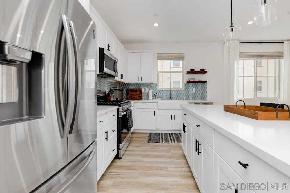 1643 Fig Tree Way Oceanside, CA 92056 - Photo 8 of 29 a kitchen with stainless steel appliances a refrigerator sink and wooden floor