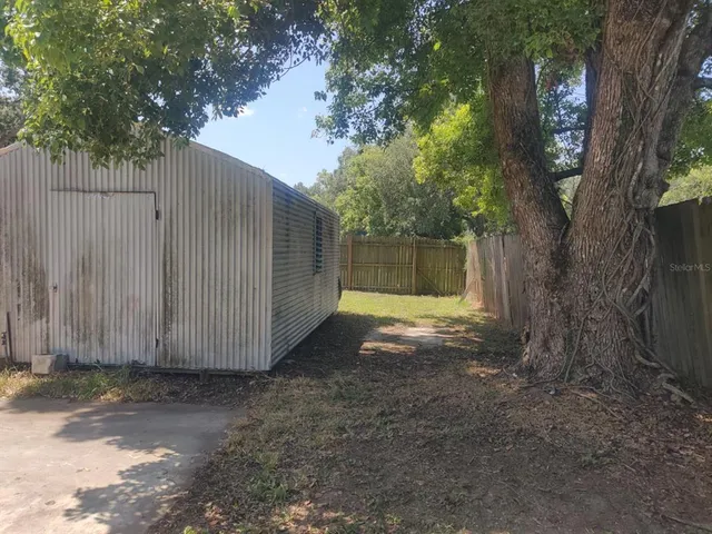 a view of a house with a yard and tree