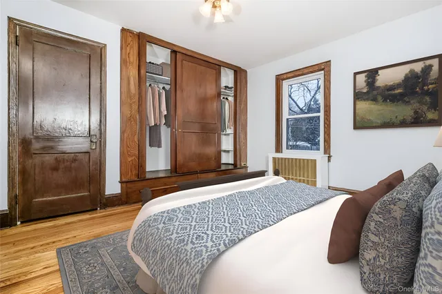 a bedroom with a bed painting on wall and a flat screen tv
