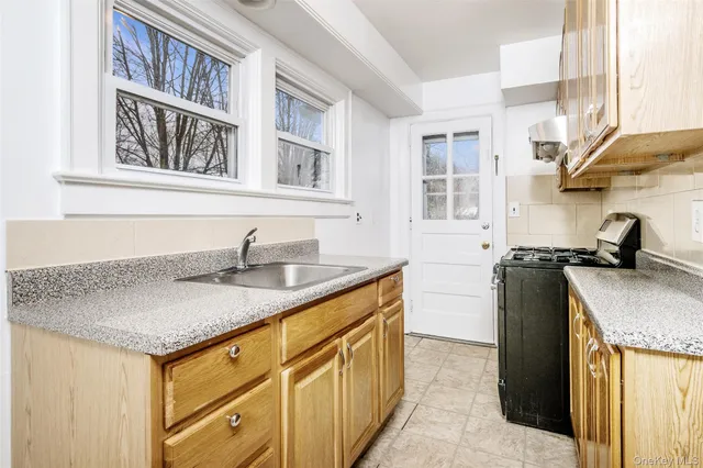 a kitchen with granite countertop a sink stove and cabinets