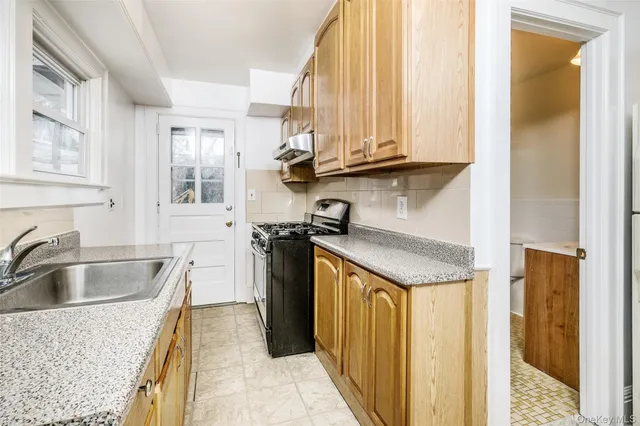a kitchen with granite countertop a sink and a refrigerator