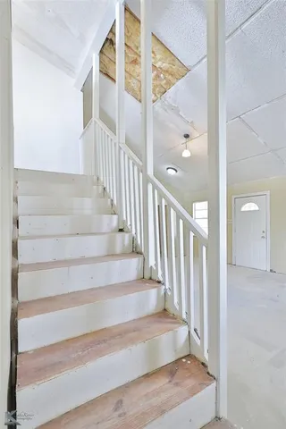 a view of staircase with white walls and windows