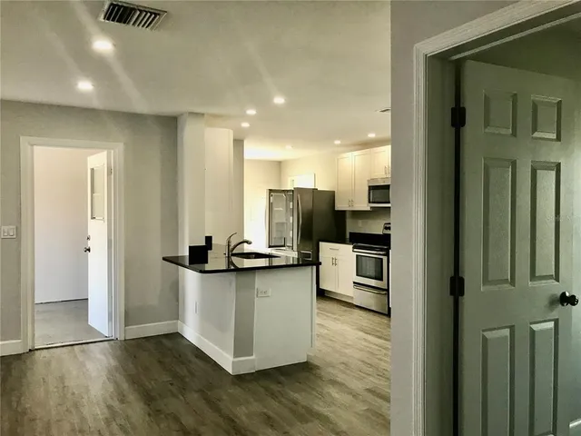 a kitchen with stainless steel appliances kitchen island granite countertop a refrigerator and a stove top oven