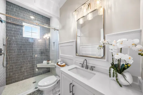 a bathroom with a sink a toilet a potted plant and shower