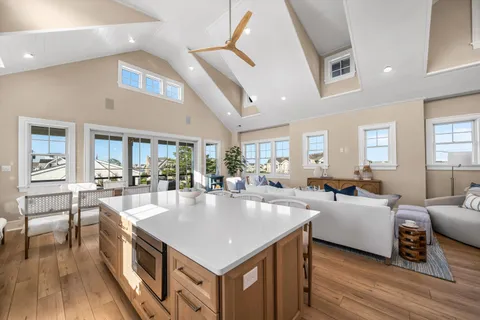 a large living room with stainless steel appliances granite countertop a couch a table and chairs