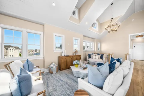 a living room with furniture kitchen view and a chandelier