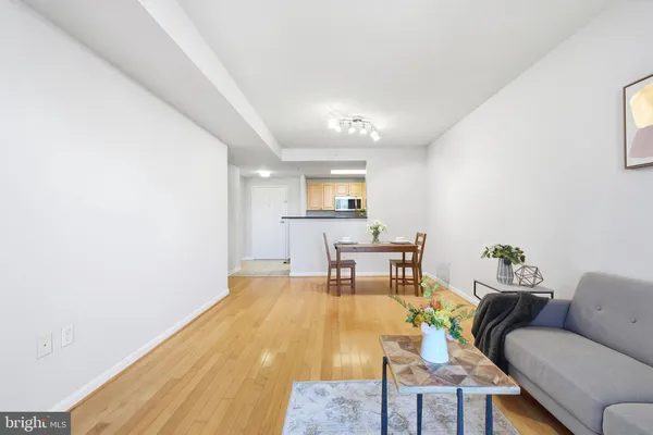 a living room with furniture and a dining table with garden view