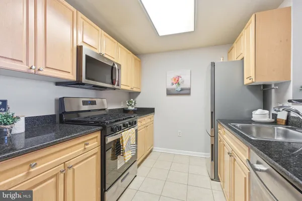 a kitchen with stainless steel appliances granite countertop a sink stove and microwave