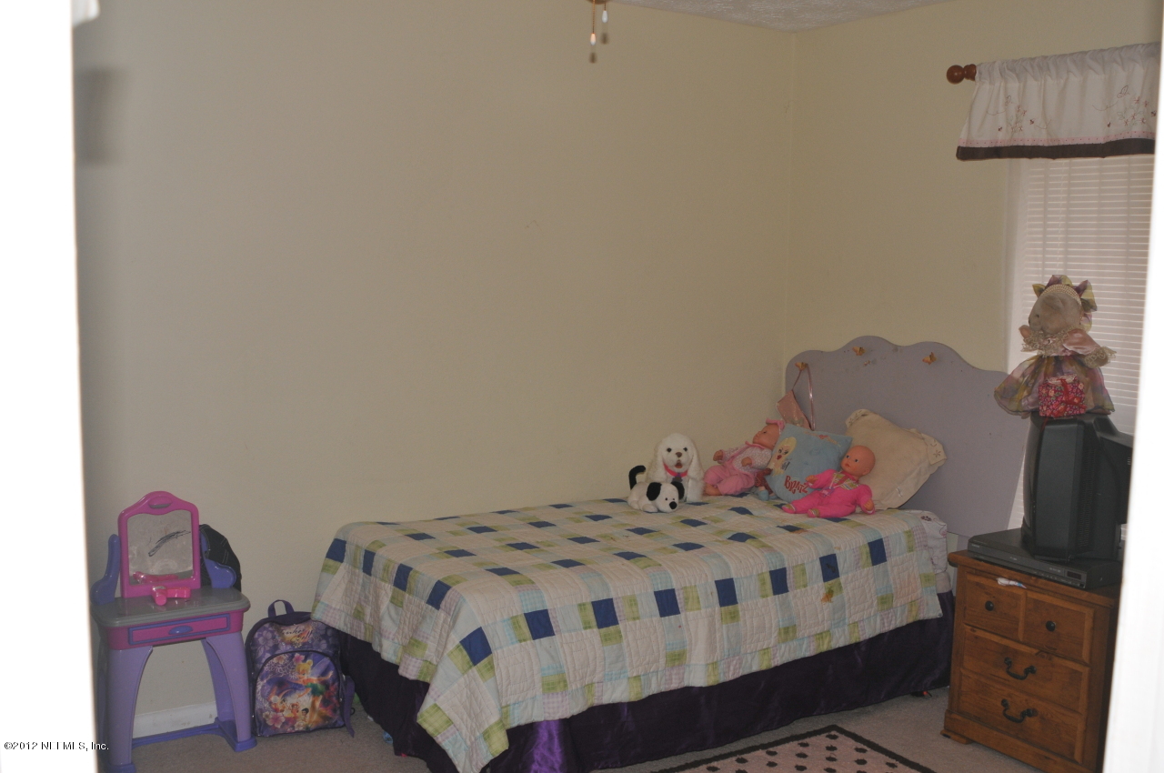 12945 Mandarin Road Jacksonville, FL 32223 - Photo 12 of 15 a bedroom with a bed a couch and dresser in it
